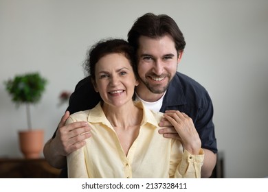 Grateful loving grown son embracing happy senior mom with tenderness, care, affection, looking at camera, smiling, laughing. Mature mother and adult child head shot portrait. Motherhood concept - Shutterstock ID 2137328411