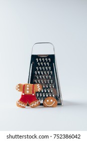 Grater And Broken Gingerbread Man, On White  