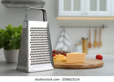 Grater and cheese on table in kitchen. Space for text