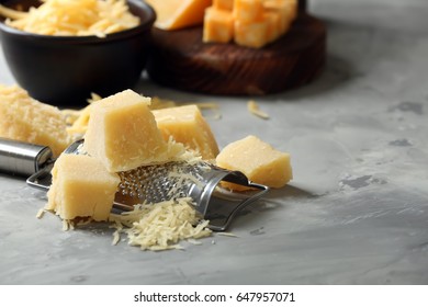 Grater and pieces of cheese on grey background - Shutterstock ID 647957071