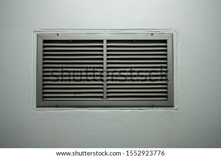 A grating of ventilation installed on the cement wall