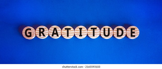 Gratitude Symbol. The Concept Word Gratitude On Wooden Circles. Beautiful Blue Table, Blue Background. Business And Gratitude Concept. Copy Space.