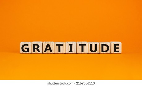 Gratitude Symbol. The Concept Word Gratitude On Wooden Cubes. Beautiful Orange Table, Orange Background. Business And Gratitude Concept. Copy Space.