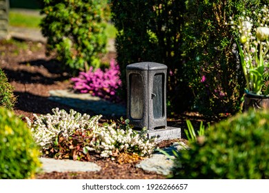 Grave Light With  Candle On A Grave With Flowers