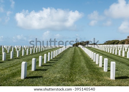 Grave markers in rows with a cloudy blue sky at Fort Rosecrans National Cemetery in San Diego, California.  Stock photo © 