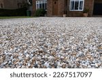 Gravel driveway leading up to a  detached suburban home