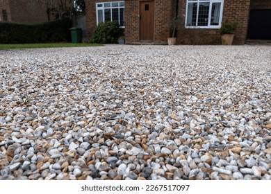 Gravel driveway leading up to a  detached suburban home - Shutterstock ID 2267517097