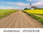 Gravel road in the country leading to the historic, yet abandoned Grand Valley Lutheran Church near Willow Bunch, SK