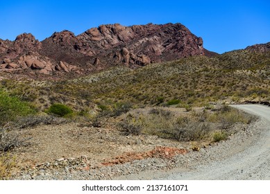 A gravel road cutting through the rugged, arid landscape around the village of Molinos, Valles Calchaquíes, Salta Province, northwest Argentina
