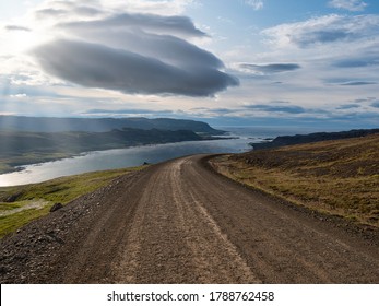 Gravel road with dramatic cloudy sky in southern fjords, Iceland
