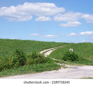 A Gravel Road On A Grassy Hillside. 