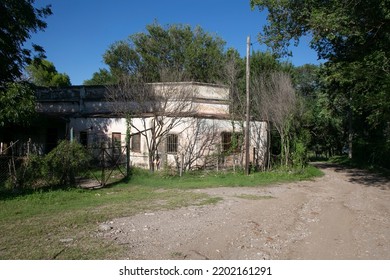 Gravel Road Skirting An Abandoned House Under A Very Blue Sky