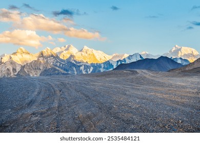 Gravel road and snow mountain nature landscape at sunset. road trip. - Powered by Shutterstock