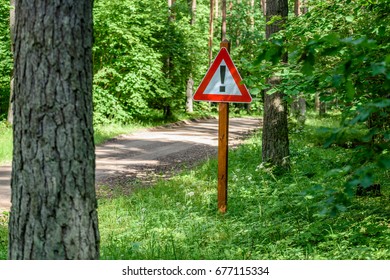 gravel road in sunny summer countryside with perspective and bright red attention sign - Shutterstock ID 677115334