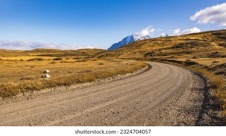 Gravel road through the wild grasslands of Patagonia, Torres del Paine National Park, Chile - Powered by Shutterstock