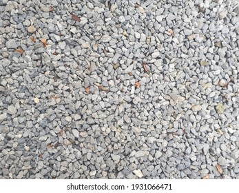 Gravel texture. Pebble stone background. Light grey closeup small rocks. Top view 