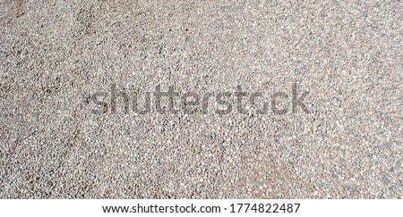 Gravel texture. Small stones, little rocks, pebbles in many shades of grey, white, brown, pink colour. Crushed granite texture. Road made of stones. Small rock background. Banner for web site.