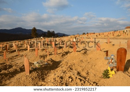 Graves in cemetery. Graveyard. Freshly-dug graves in a rows. Rising number of dead after the coronavirus disease. COVID-19 outbreak. Recently buried people.
