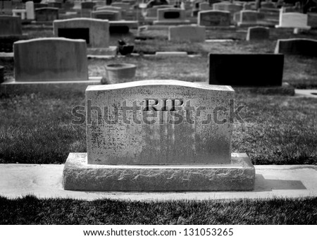 Gravestone in cemetery with words RIP rest in peace carved