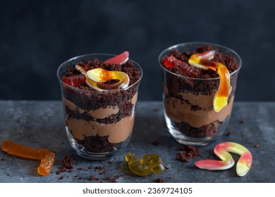 Graveyard dirt chocolate cups with  gummy worms, sweet and funny dessert for Halloween party - Powered by Shutterstock