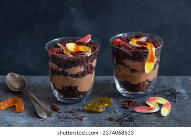 Graveyard dirt chocolate cups with  gummy worms, sweet and funny dessert for Halloween party - Powered by Shutterstock