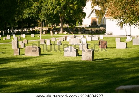 Graveyard on a sunny day. Cemetery graveyard white and grey tombstones.
