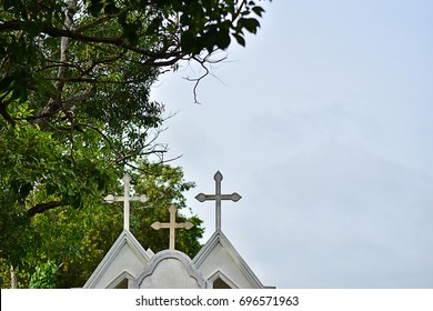 Graveyard With White Cross In The Green Meadow