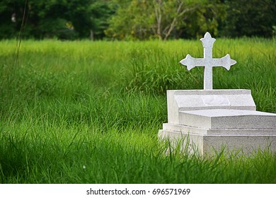 Graveyard With White Cross In The Green Meadow