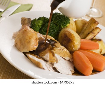 Gravy Being Poured Over A Plate Of Roast Chicken