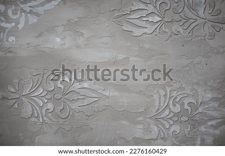 Gray background of decorative plaster with abstract spots. Unusual silver wall texture with beautiful patterns, creative surface background. Dressing coating for building cladding.