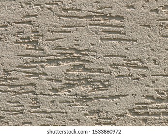 Gray background facade plaster . Monolithic plaster decorative backdrop. Single layer scraped cement plaster wallpaper. Gold exterior building structure backdrop. Silica sand cement wall plaster