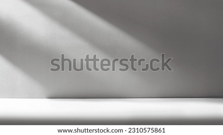 Gray background for product presentation with shadows and light from the window.