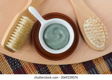 Gray (blue) Bentonite Clay In A Small Bowl, Body Brush And Wooden Hairbrush. Clay Texture Close Up. Diy Hair Mask And Body Wrap Recipe. Natural Beauty Treatment And Spa. Top View, Copy Space