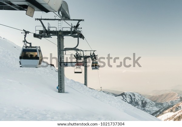 gray cable car lift at ski resort. vintage\
winter picture. cable car, cableway, ropeway, cable way, cable\
railway, funicular railway, aerial cableway, rope road. Medeo\
Kazakhstan. ski resort\
Shymbulak