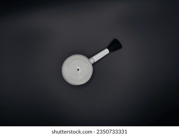 Gray camera lens cleaner on a black background