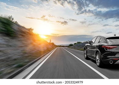 Gray car on a scenic road. Car on the road surrounded by a magnificent natural landscape in the rays of sunset or dawn. - Powered by Shutterstock