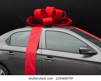 Gray Car With Red Ribbon On Dark Black Background. Perfect Gift Present