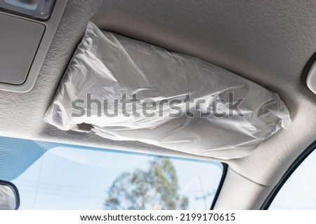Gray car sun visor with plastic wrap