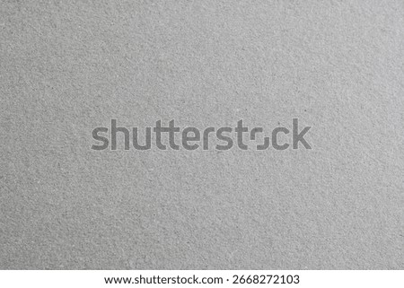 Gray cardboard texture, showcasing the rough, fibrous surface of recycled paper. A rustic and eco-friendly background.