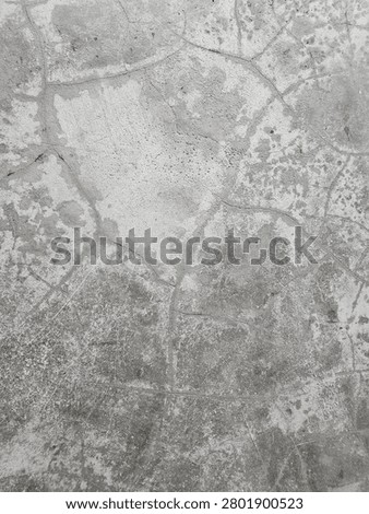 Gray cement plaster surface background displaying a network of thin crazing cracks from weathering.