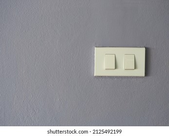 Gray Cement Wall Has An Electrical Plug Or Switch On The Right Hand Side