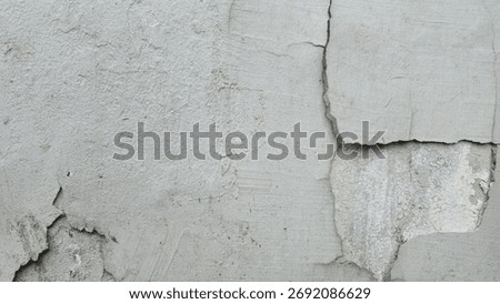 Gray cement wall surface with cracks and peeling paint revealing inner layers, showing rough texture and aging details, perfect for background or vintage design.
