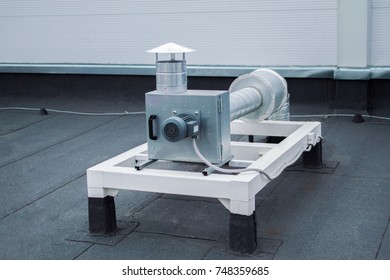 Gray Centrifugal Fan With Ductwork On The Roof