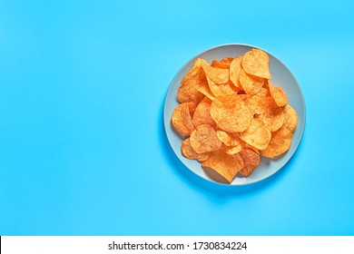 Gray Ceramic Bowl Full Of Potato Chips On Blue Background. Space For Text. Top View