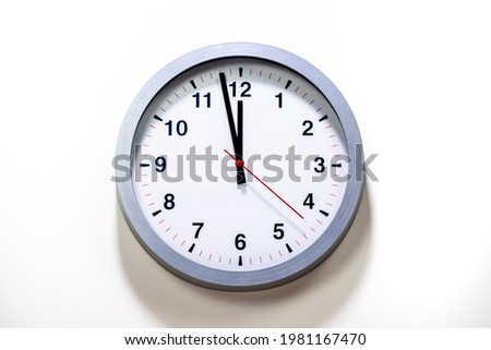 Gray clock face of a wall clock show the time. It's close to 12 o'clock. The latest report of the atomic scientist shows the doomsday clock 100 seconds to twelve.  Time is running out for mankind.