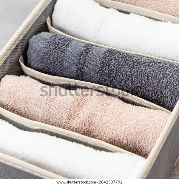 Gray closet\
organizer with towels. Storage organization. Order and cleanliness.\
Neatly folded towels. Close\
up