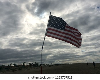 Gray clouds with the flag waving in the foreground.