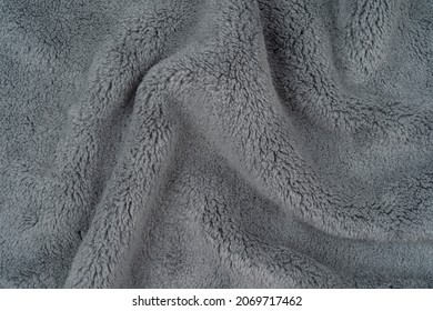 Gray color plush fabric background texture, wrinkled on the table, background pattern of soft warm material, cozy winter concept