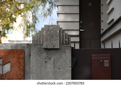 Gray Concrete Fence Post With Austere Decor On Top