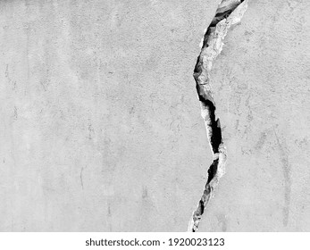 Gray cracked concrete texture background, close up. Big crack on the wall. Black and white. Wall of the house with a huge crack.